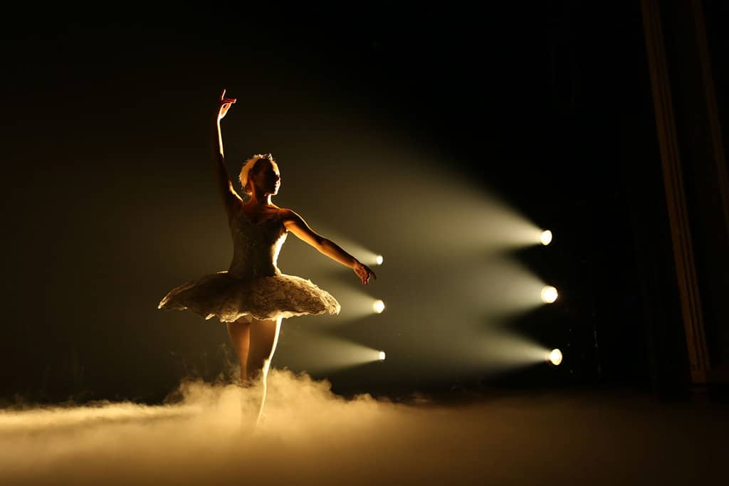 Ballerina wird von Scheinwerfer beleuchtet